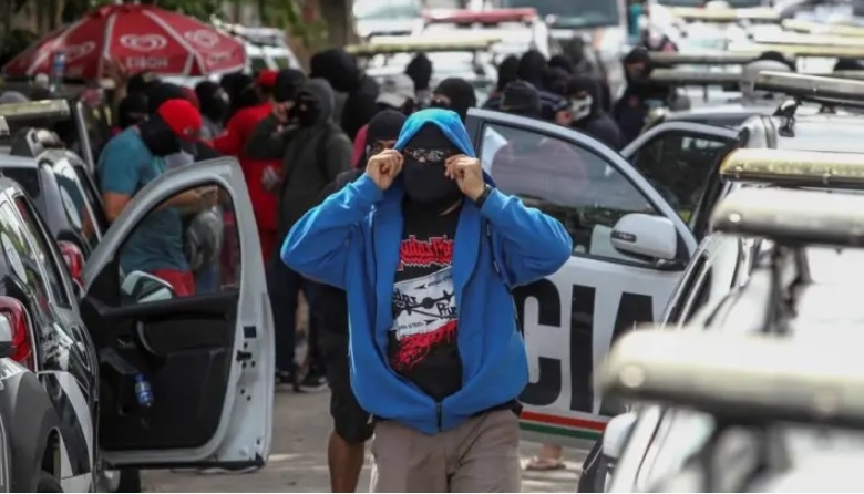 Policiais amotinados cobrem o rosto durante protesto